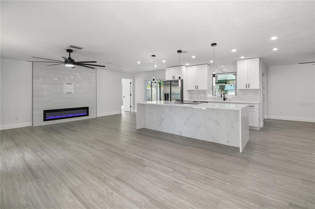 11492 93rd Street Largo, FL 33773 - Photo 5 of 37 a large kitchen with stainless steel appliances kitchen island a large counter top and a wooden floors