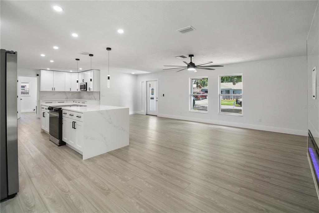 11492 93rd Street Largo, FL 33773 - Photo 7 of 37 a large kitchen with stainless steel appliances granite countertop a large counter top and a stove with wooden floor