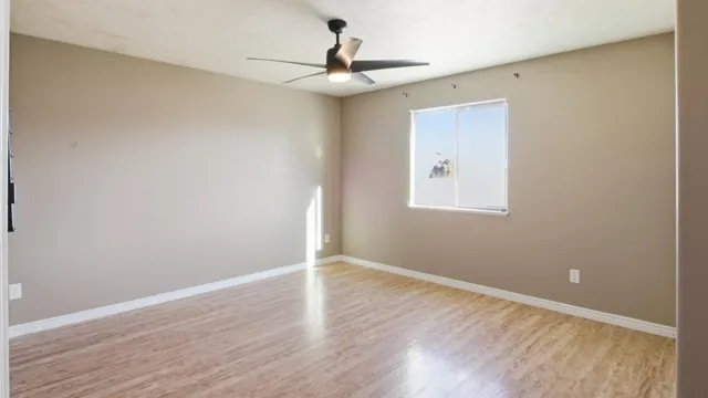 a view of a livingroom with wooden floor and a ceiling fan