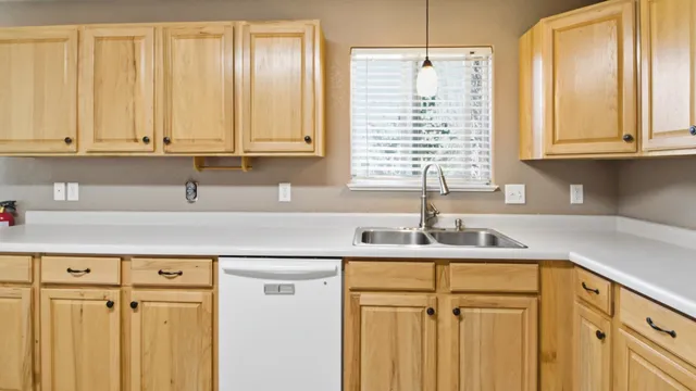 a kitchen with granite countertop white cabinets and stainless steel appliances