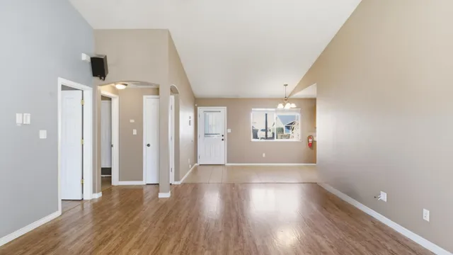 a view of a hallway with wooden floor and a bathroom