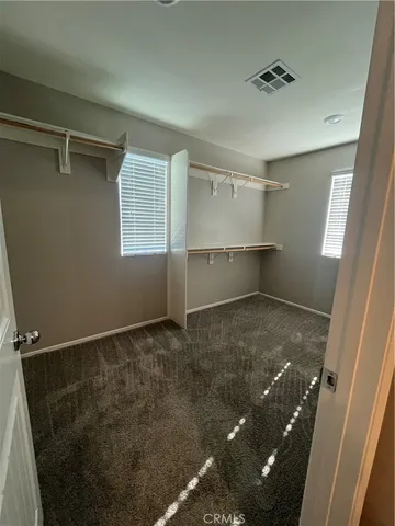 an empty room with ceiling fan and window