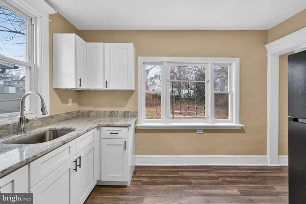 a kitchen with granite countertop a sink cabinets and window