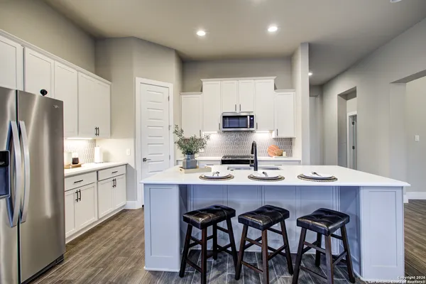 a kitchen with stainless steel appliances granite countertop a white cabinets and a sink