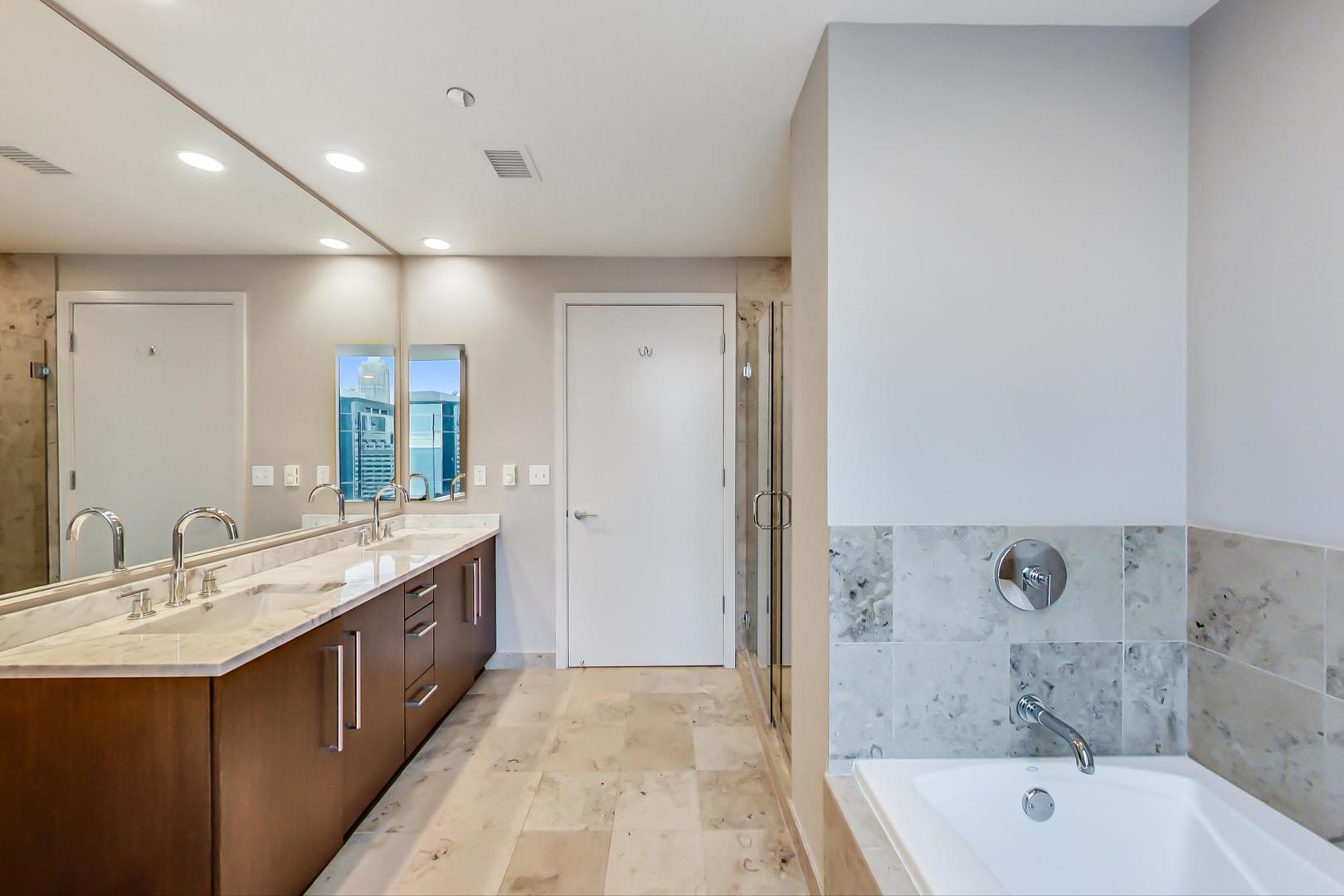 60 East Monroe Street, Unit 4404 Chicago, IL 60603 - Photo 12 of 34 a bathroom with a tub sink shower and mirror