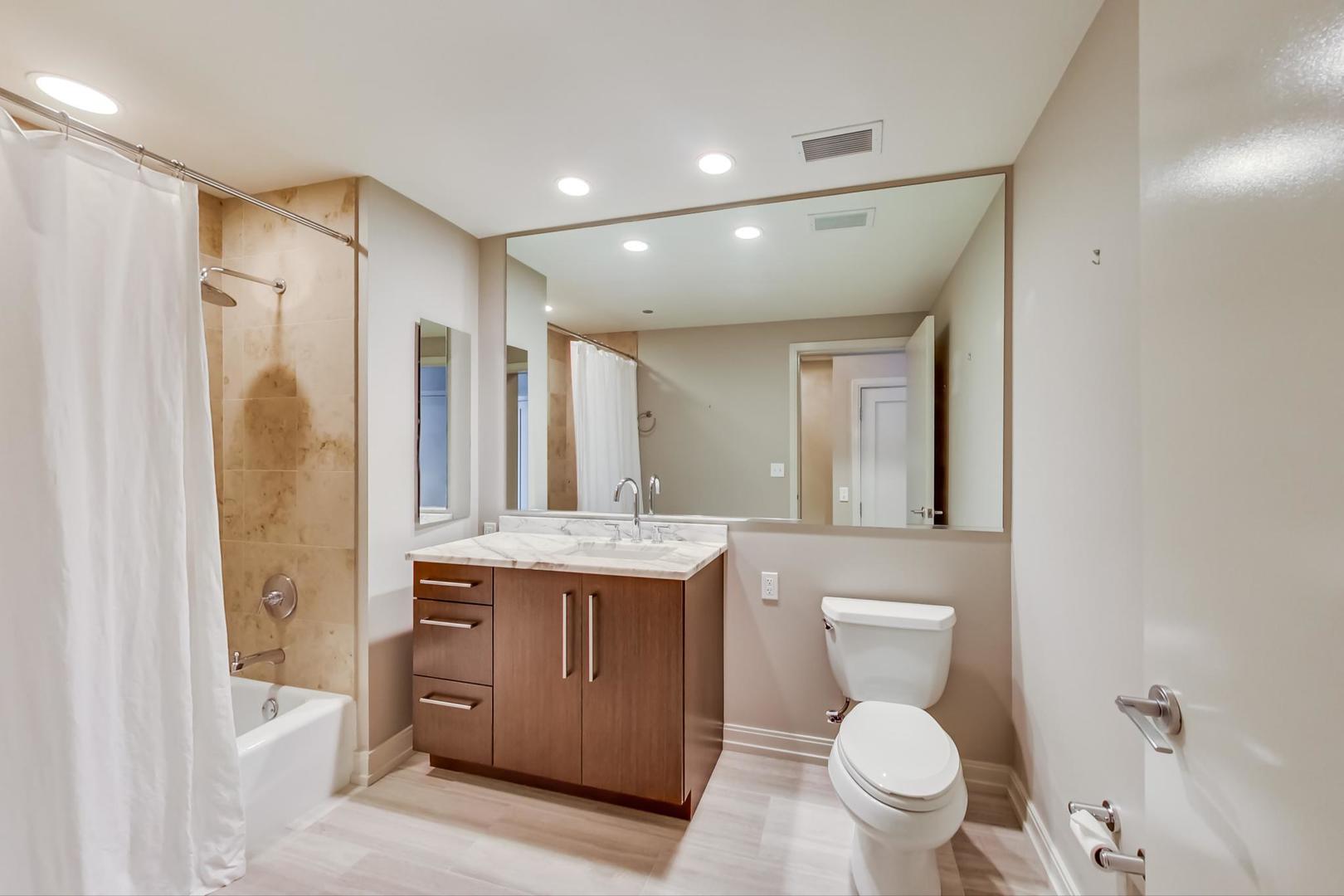 60 East Monroe Street, Unit 4404 Chicago, IL 60603 - Photo 16 of 34 a bathroom with a granite countertop toilet sink and mirror