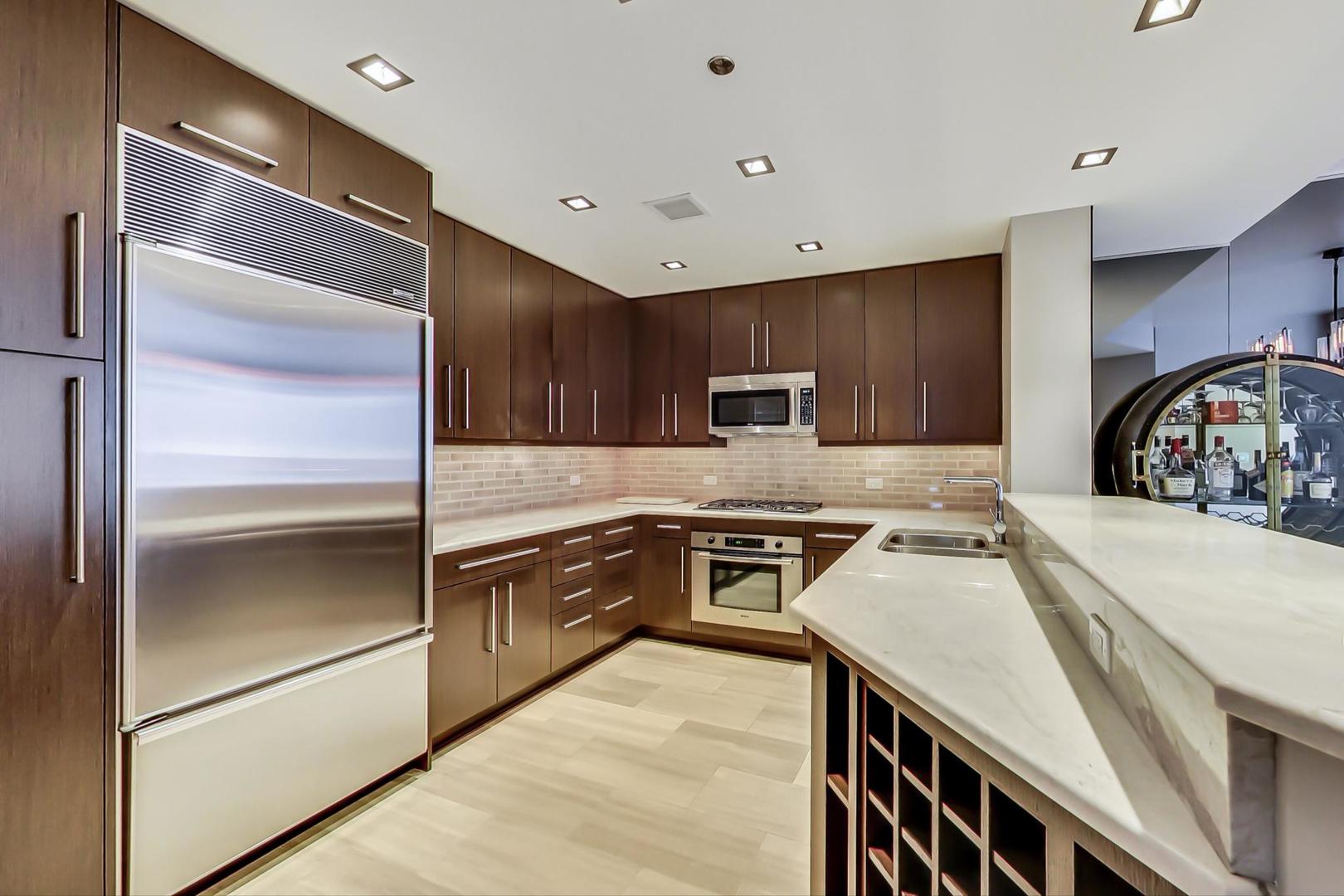60 East Monroe Street, Unit 4404 Chicago, IL 60603 - Photo 5 of 34 a kitchen with cabinets and stainless steel appliances