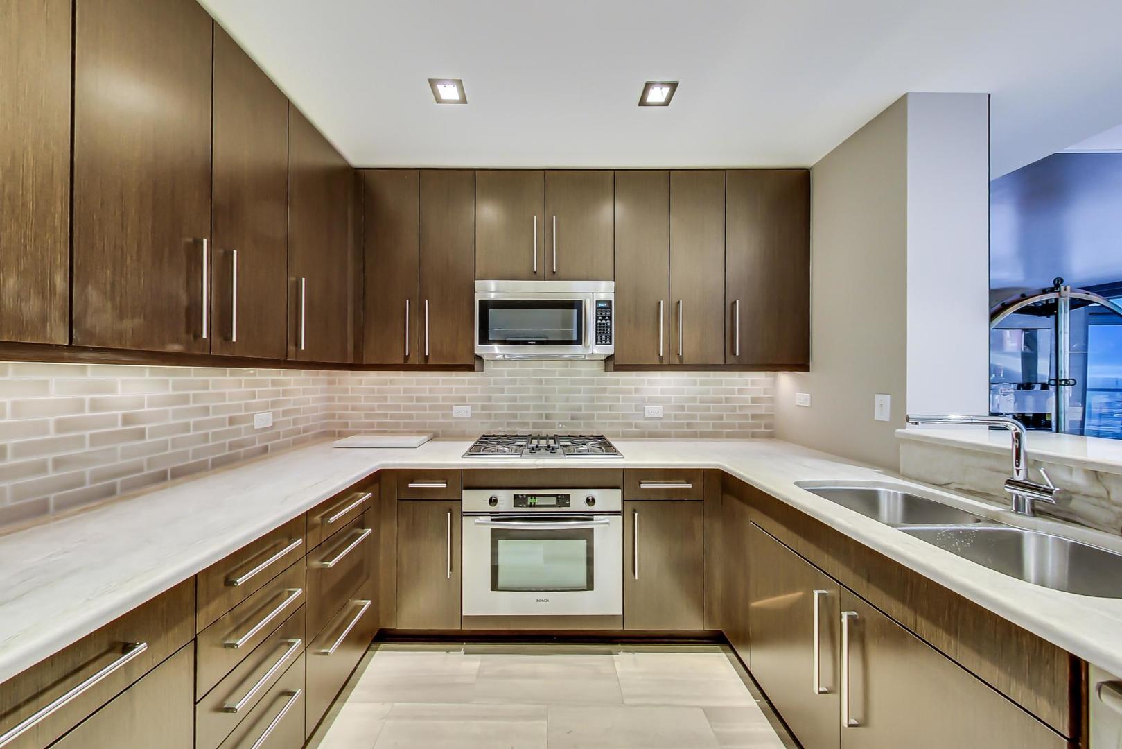 60 East Monroe Street, Unit 4404 Chicago, IL 60603 - Photo 6 of 34 a kitchen with a sink cabinets and stainless steel appliances