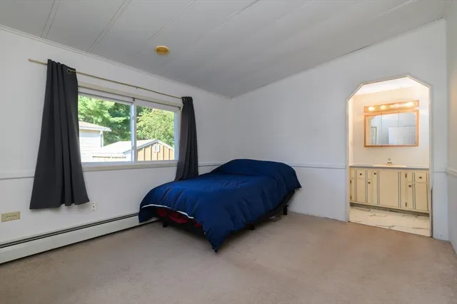 a spacious bedroom with a bed and a flat tv screen next to a large window