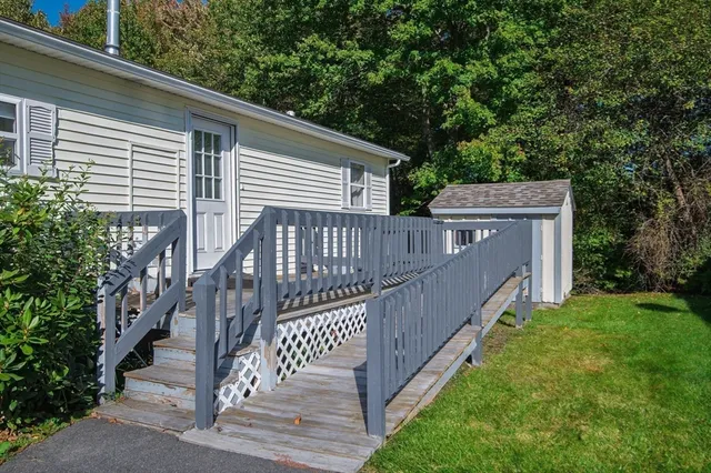a view of a house with backyard and deck