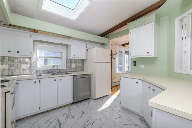 a kitchen with granite countertop a sink and white cabinets
