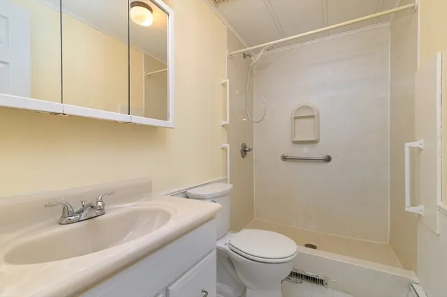 a bathroom with a granite countertop sink toilet and shower
