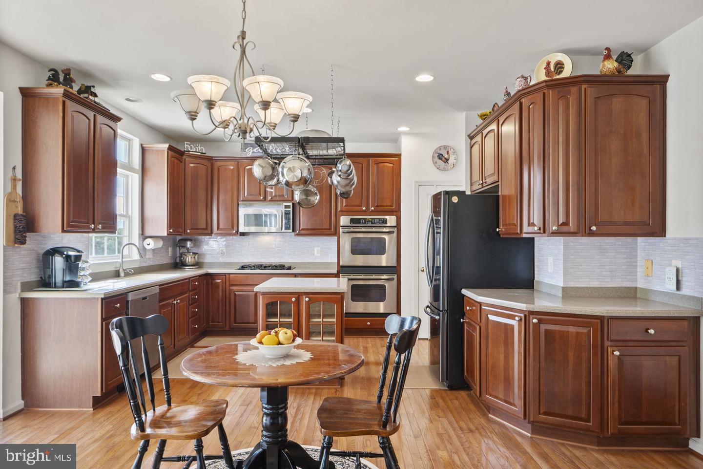 6528 Atkins Way Gainesville, VA 20155 - Photo 11 of 42 a kitchen with cabinets a sink stainless steel appliances and dining table