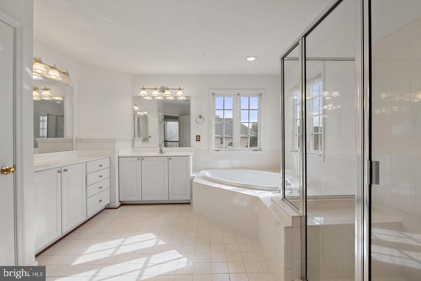 6528 Atkins Way Gainesville, VA 20155 - Photo 24 of 42 a spacious bathroom with a double vanity sink a mirror a bathtub and shower
