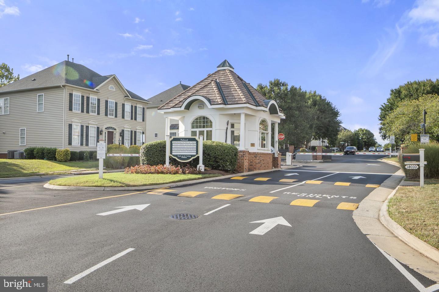 6528 Atkins Way Gainesville, VA 20155 - Photo 40 of 42 a view of a white house with a large swimming pool and a lawn chairs under an umbrella