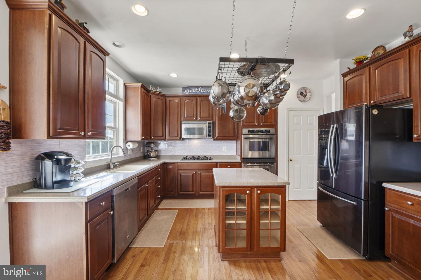 6528 Atkins Way Gainesville, VA 20155 - Photo 10 of 42 a kitchen with stainless steel appliances granite countertop a refrigerator a sink dishwasher a stove and a dining table with wooden floor