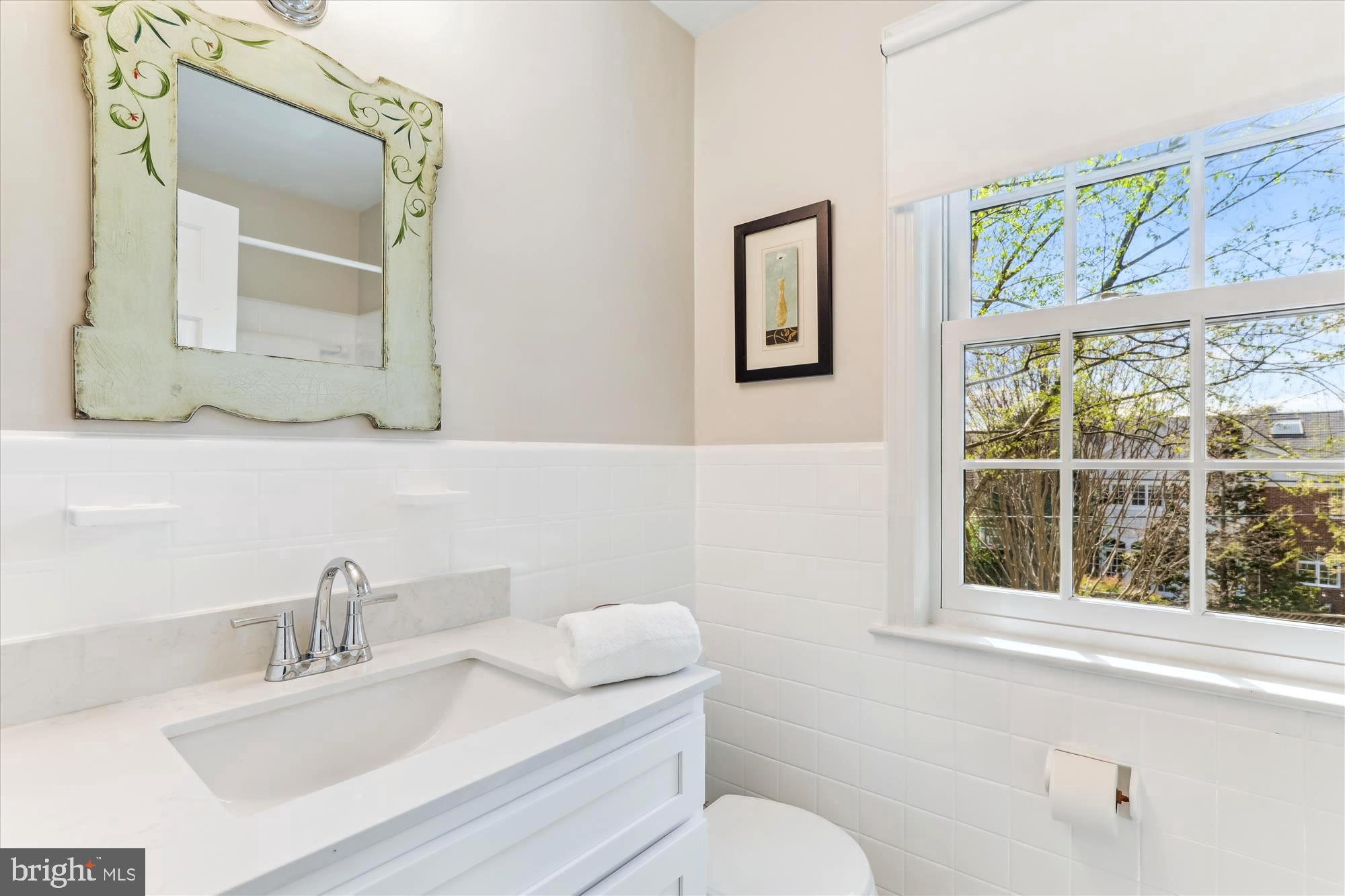 3568 Appleton Street Northwest Washington, DC 20008 - Photo 35 of 57 a bathroom with a toilet a sink a mirror and a window