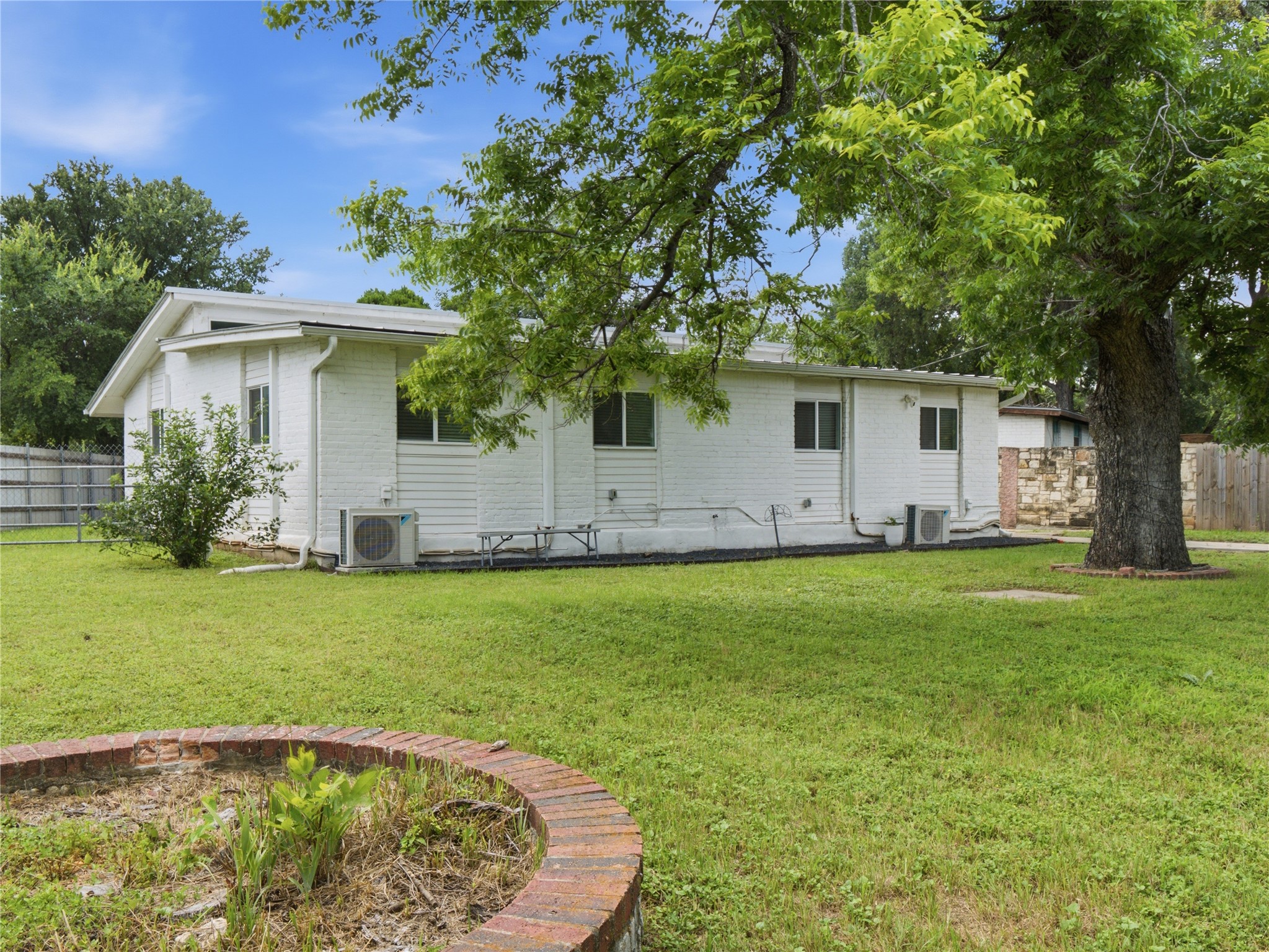 1108 Jolena Circle Austin, TX 78721 - Photo 19 of 21 A well-maintained side yard offers ample green space and a quaint brick planter.
