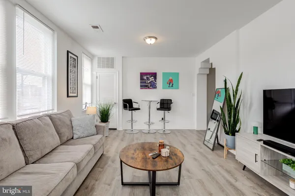a living room with furniture a flat screen tv and a large window
