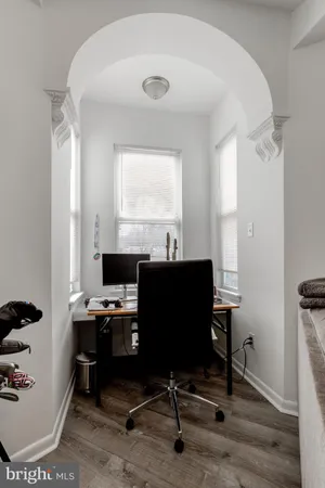 a view of a workspace with furniture and a window
