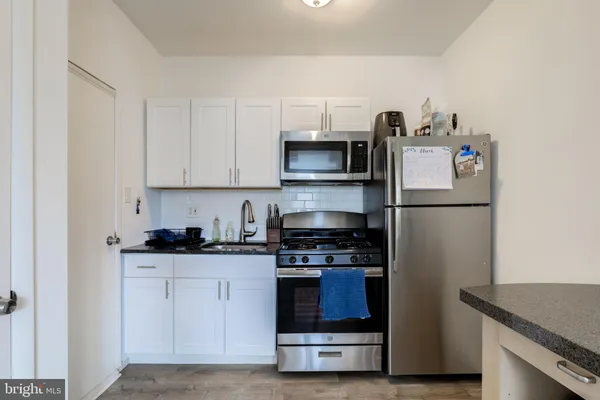 a kitchen with stainless steel appliances granite countertop a refrigerator and a stove top oven