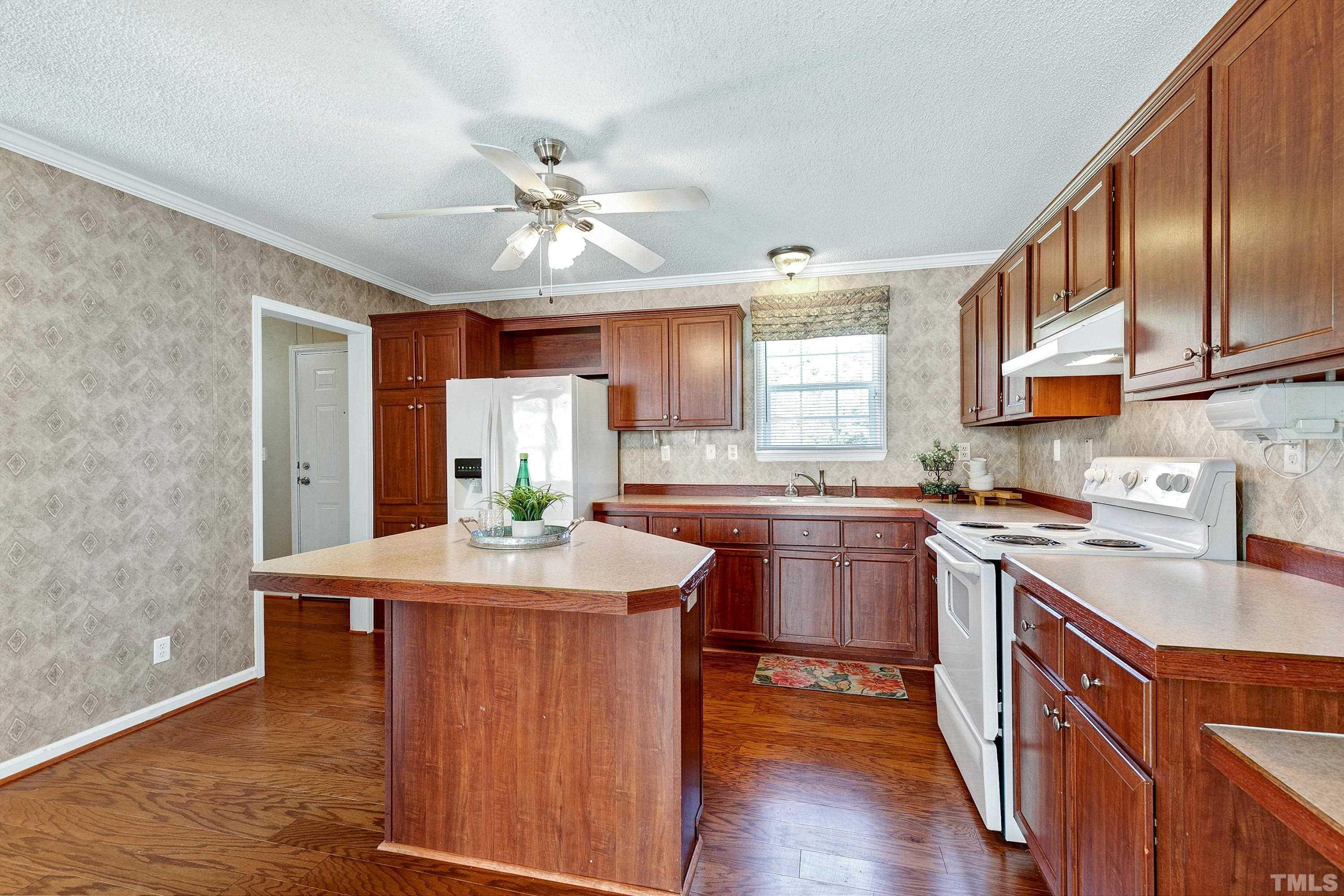 8308 South Creek Road Willow Spring, NC 27592 - Photo 20 of 42 a kitchen with kitchen island granite countertop a sink a stove cabinets counter top space and stainless steel appliances