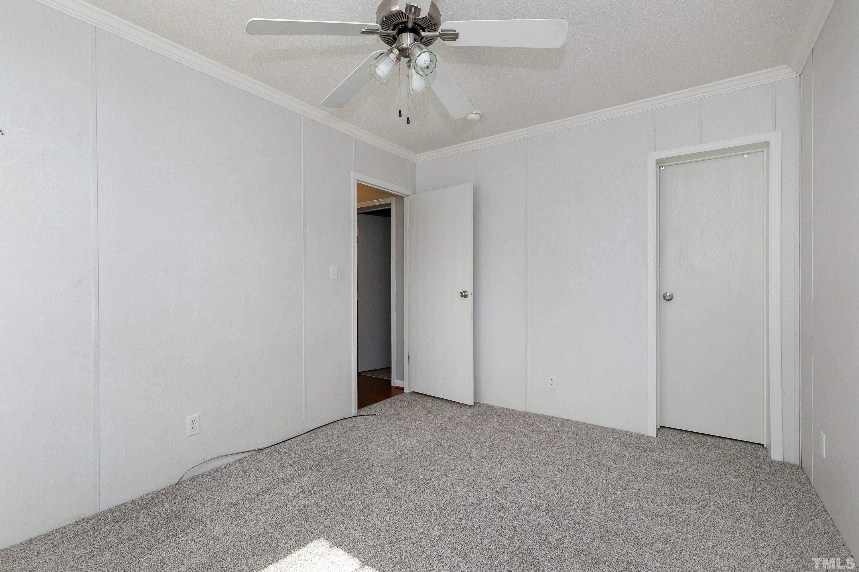 8308 South Creek Road Willow Spring, NC 27592 - Photo 25 of 42 an empty room with chandelier fan and windows