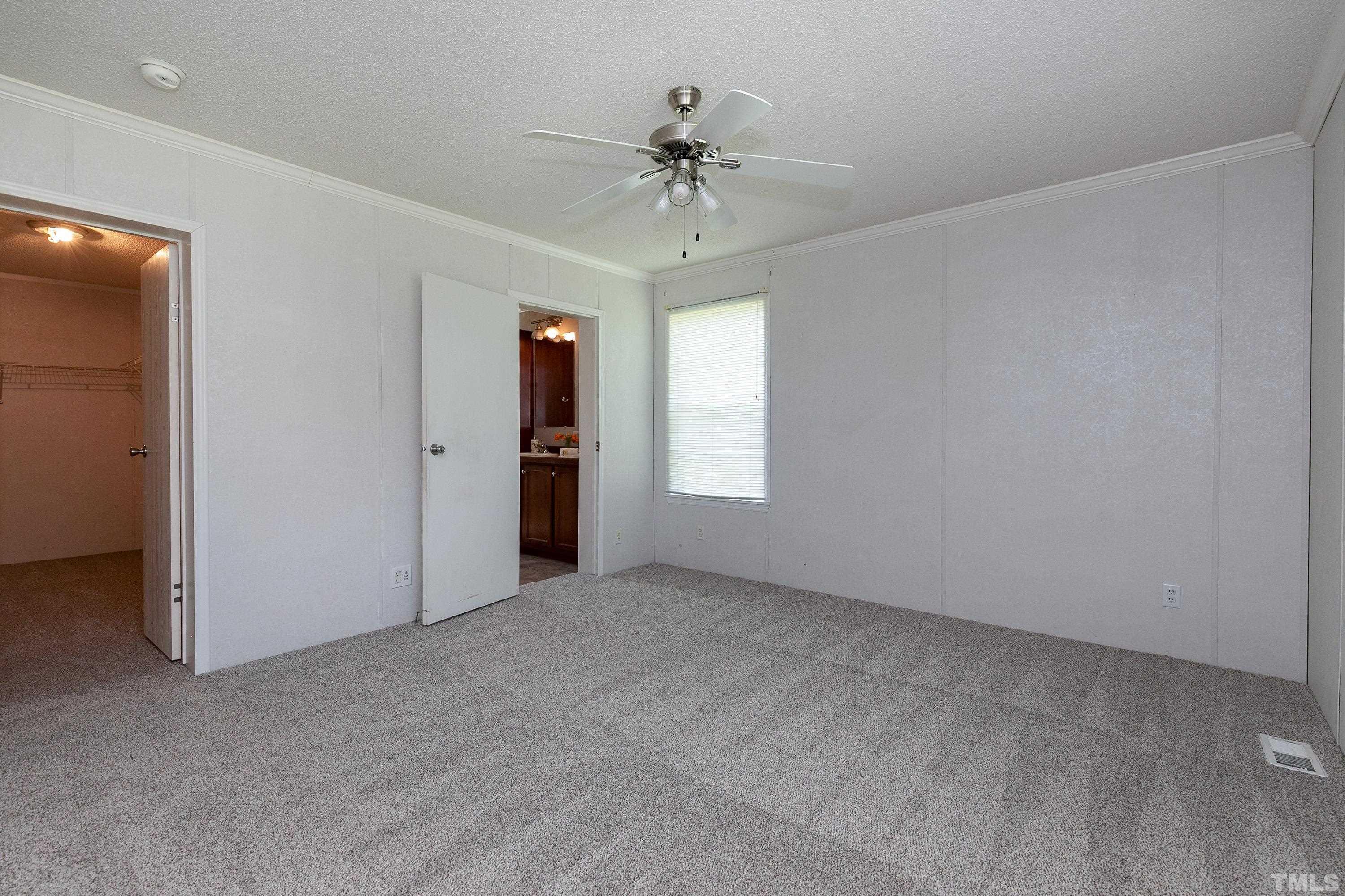 8308 South Creek Road Willow Spring, NC 27592 - Photo 29 of 42 an empty room with a ceiling fan and window