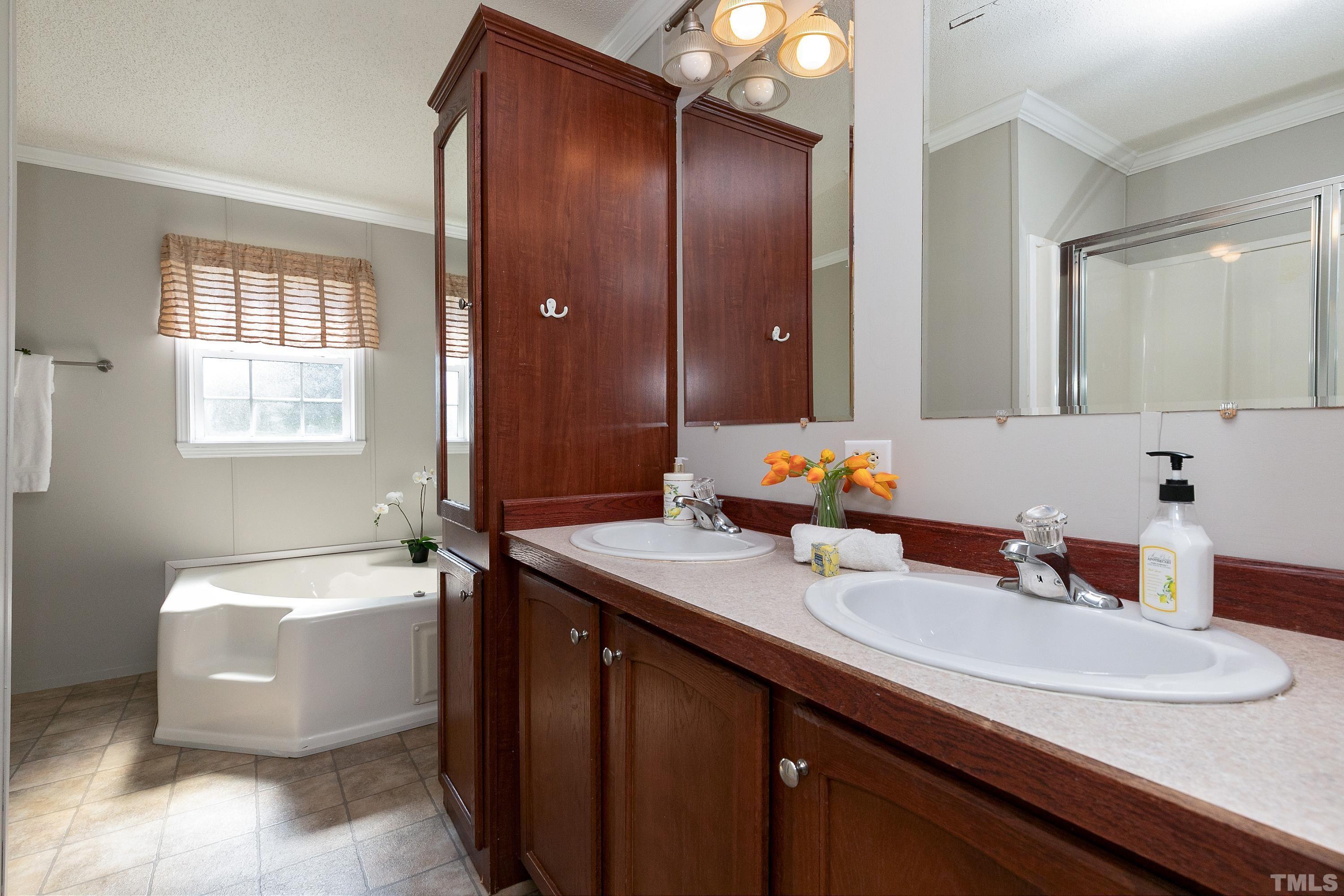 8308 South Creek Road Willow Spring, NC 27592 - Photo 31 of 42 a bathroom with a sink double vanity granite tub and a mirror