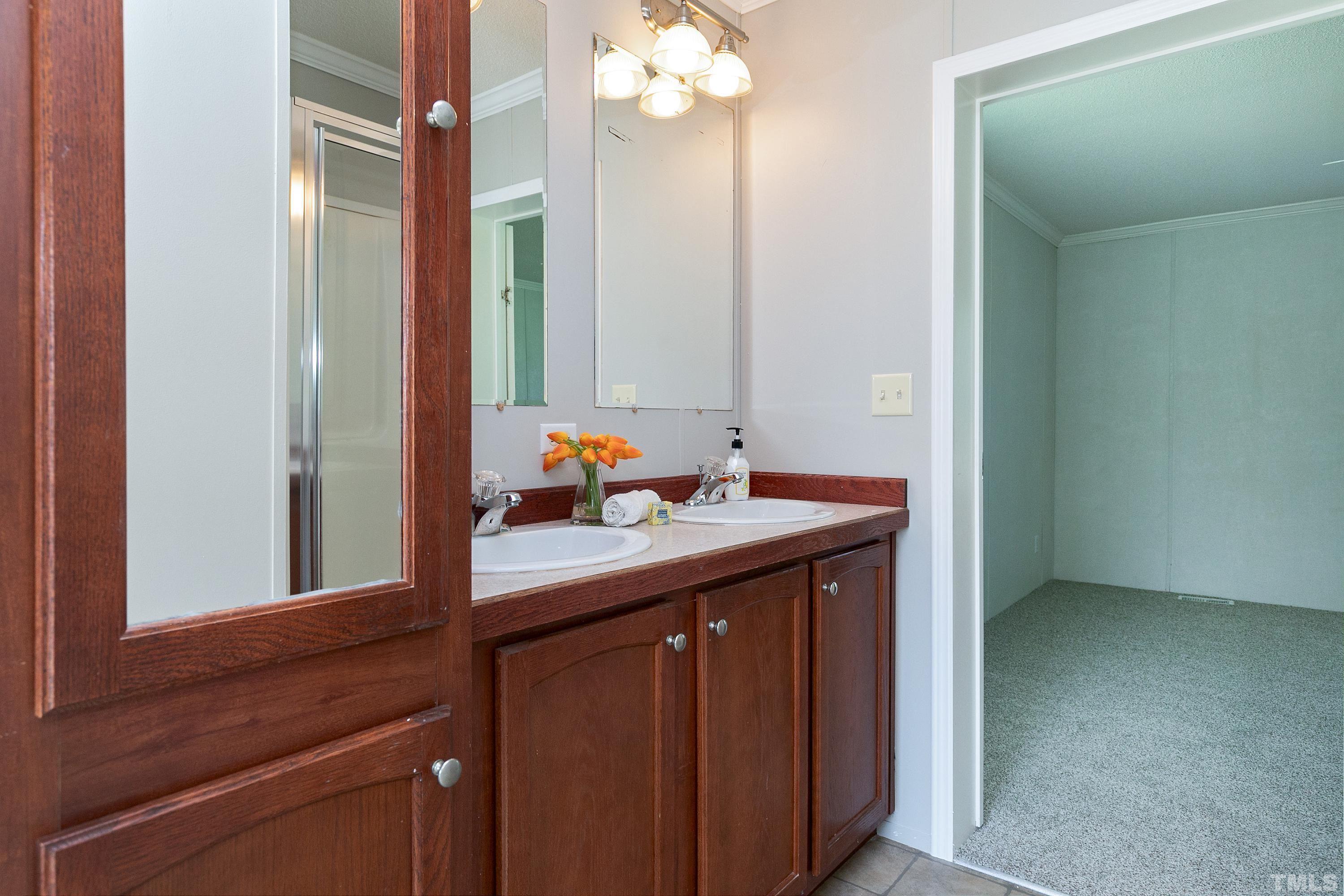 8308 South Creek Road Willow Spring, NC 27592 - Photo 35 of 42 a bathroom with a granite countertop sink and a mirror