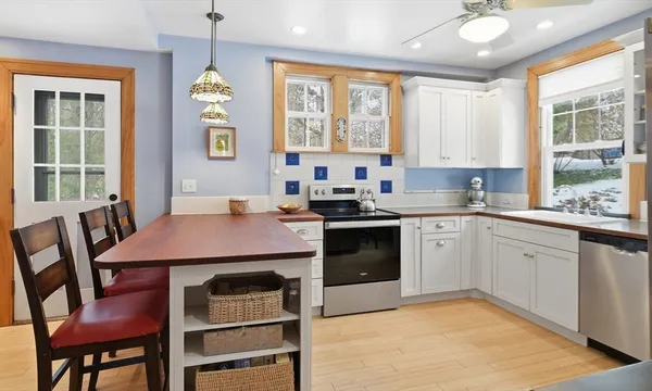 a kitchen a sink a window and chairs