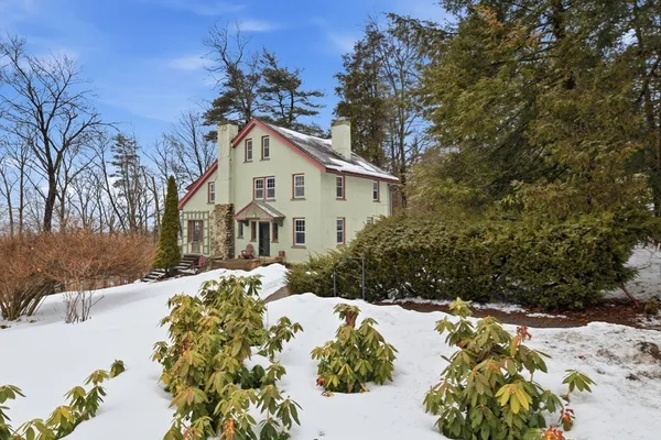 a front view of a house with a yard covered with snow