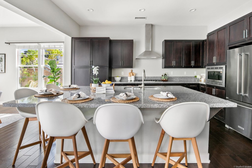 7060 Sitio Caliente Carlsbad, CA 92009 - Photo 12 of 39 a kitchen with a dining table chairs and refrigerator