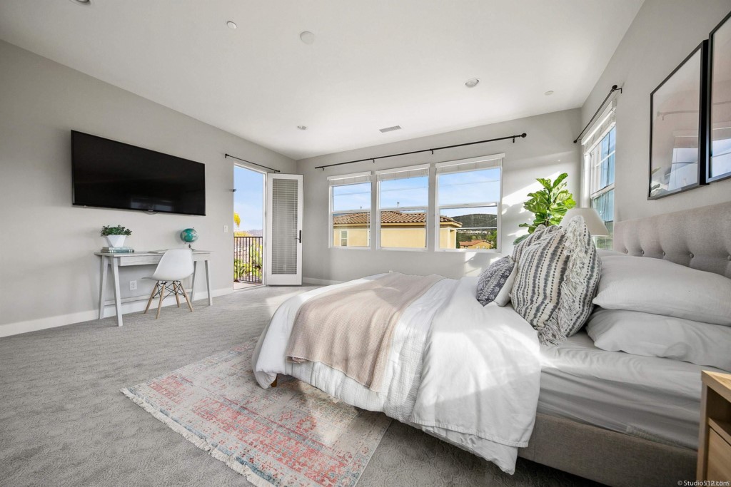 7060 Sitio Caliente Carlsbad, CA 92009 - Photo 21 of 39 a bedroom with a bed a television and a large window