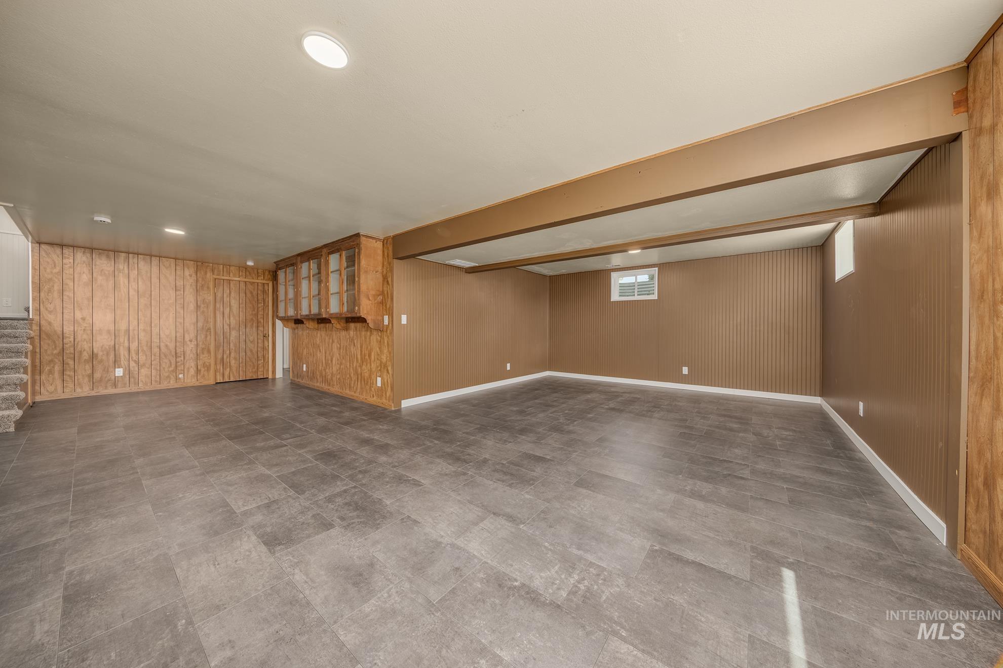 748 Pringle Road Weiser, ID 83672 - Photo 22 of 47 Spacious lower-level room featuring wood-finish wall paneling, ceiling-mounted lighting, and durable tile flooring