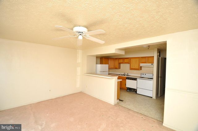 a kitchen with a refrigerator and white cabinets