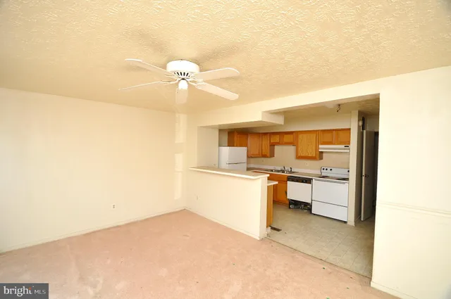 a kitchen with a refrigerator and white cabinets
