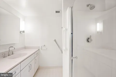 a bathroom with a granite countertop sink a shower and a mirror