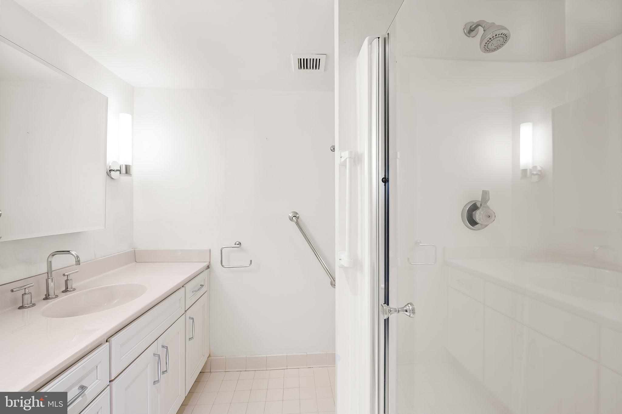 111 Hamlet Hill Road, Unit 412 Baltimore, MD 21210 - Photo 20 of 33 a bathroom with a granite countertop sink a shower and a mirror