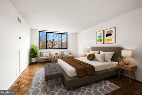 a bedroom with a bed and a painting on the wall