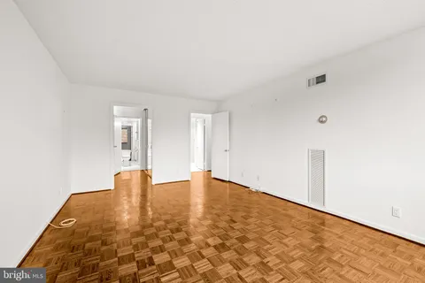 a view of empty room with wooden floor