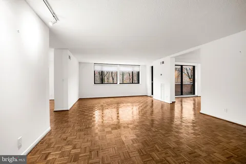 a view of empty room with wooden floor and fireplace