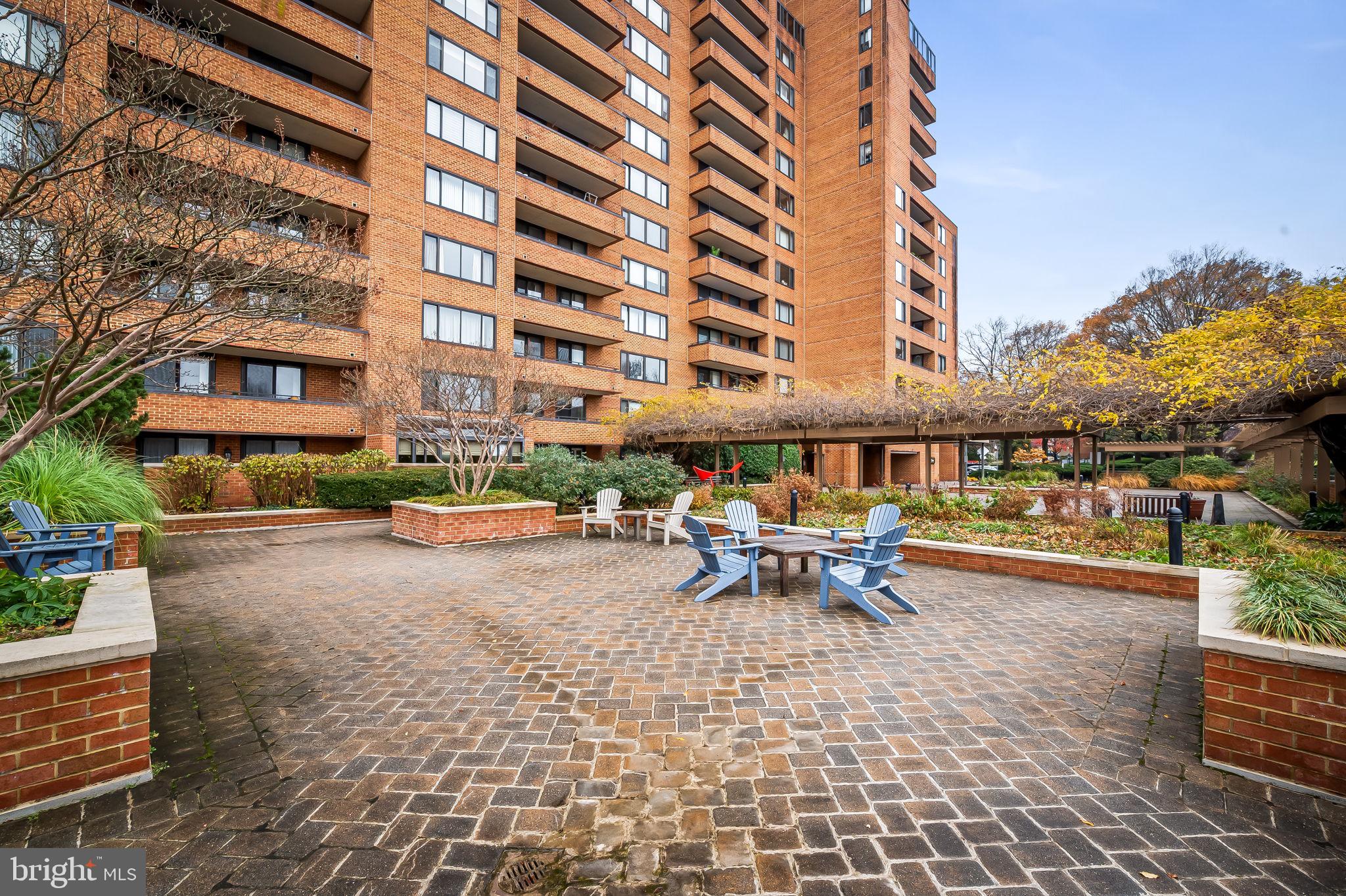 111 Hamlet Hill Road, Unit 412 Baltimore, MD 21210 - Photo 32 of 33 a view of a patio with a table and chairs under an umbrella
