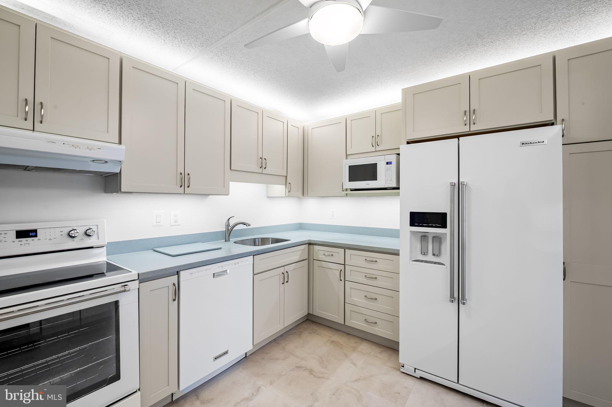111 Hamlet Hill Road, Unit 412 Baltimore, MD 21210 - Photo 6 of 33 a kitchen with white cabinets and white appliances
