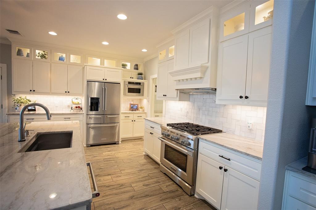 4827 Green Acres Road Graham, TX 76450 - Photo 20 of 32 a kitchen with kitchen island stainless steel appliances a stove a sink and a refrigerator