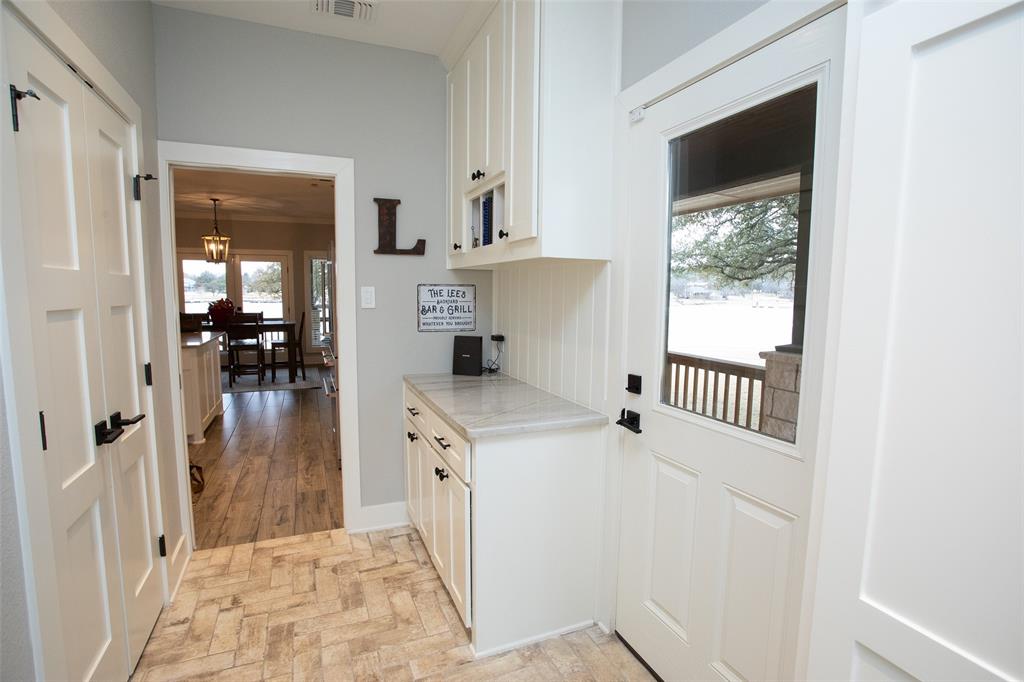 4827 Green Acres Road Graham, TX 76450 - Photo 21 of 32 a view of a hallway to a livingroom with wooden floor and a window
