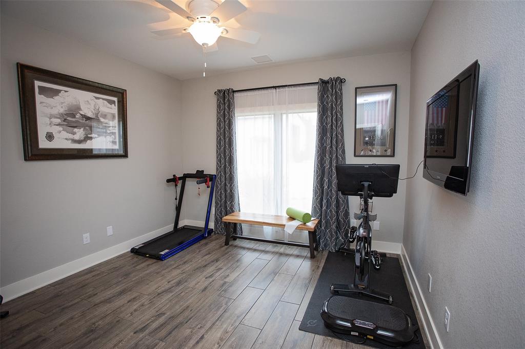 4827 Green Acres Road Graham, TX 76450 - Photo 24 of 32 a room with gym equipment and a flat screen tv
