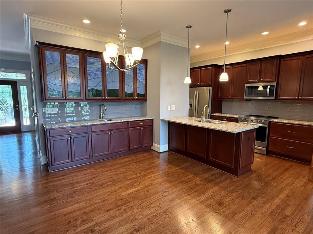 1950 Buford Dam Road, Unit 202 Cumming, GA 30041 - Photo 14 of 40 a kitchen with stainless steel appliances kitchen island granite countertop a stove a sink and a wooden cabinets