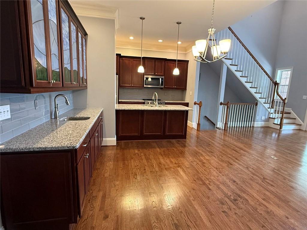 1950 Buford Dam Road, Unit 202 Cumming, GA 30041 - Photo 17 of 40 a kitchen with stainless steel appliances granite countertop a sink a stove and a wooden floor