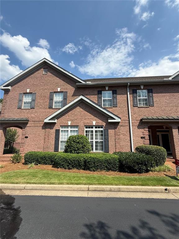 1950 Buford Dam Road, Unit 202 Cumming, GA 30041 - Photo 6 of 40 a front view of a house with a yard and potted plants